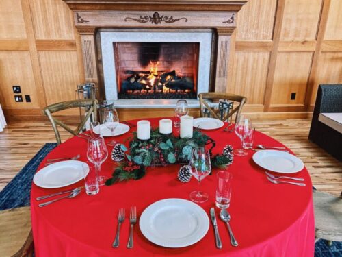 Holiday table set in front of a fireplace